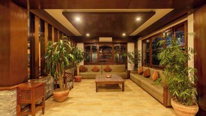 A spacious lobby with a wooden floor, a central seating area with a sofa and a coffee table, and large potted plants. - Mount View Pokhara (Pokhara)