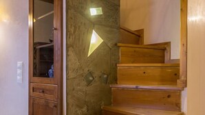 Eine Holztreppe mit Handlauf und einer Holztür mit Spiegel.