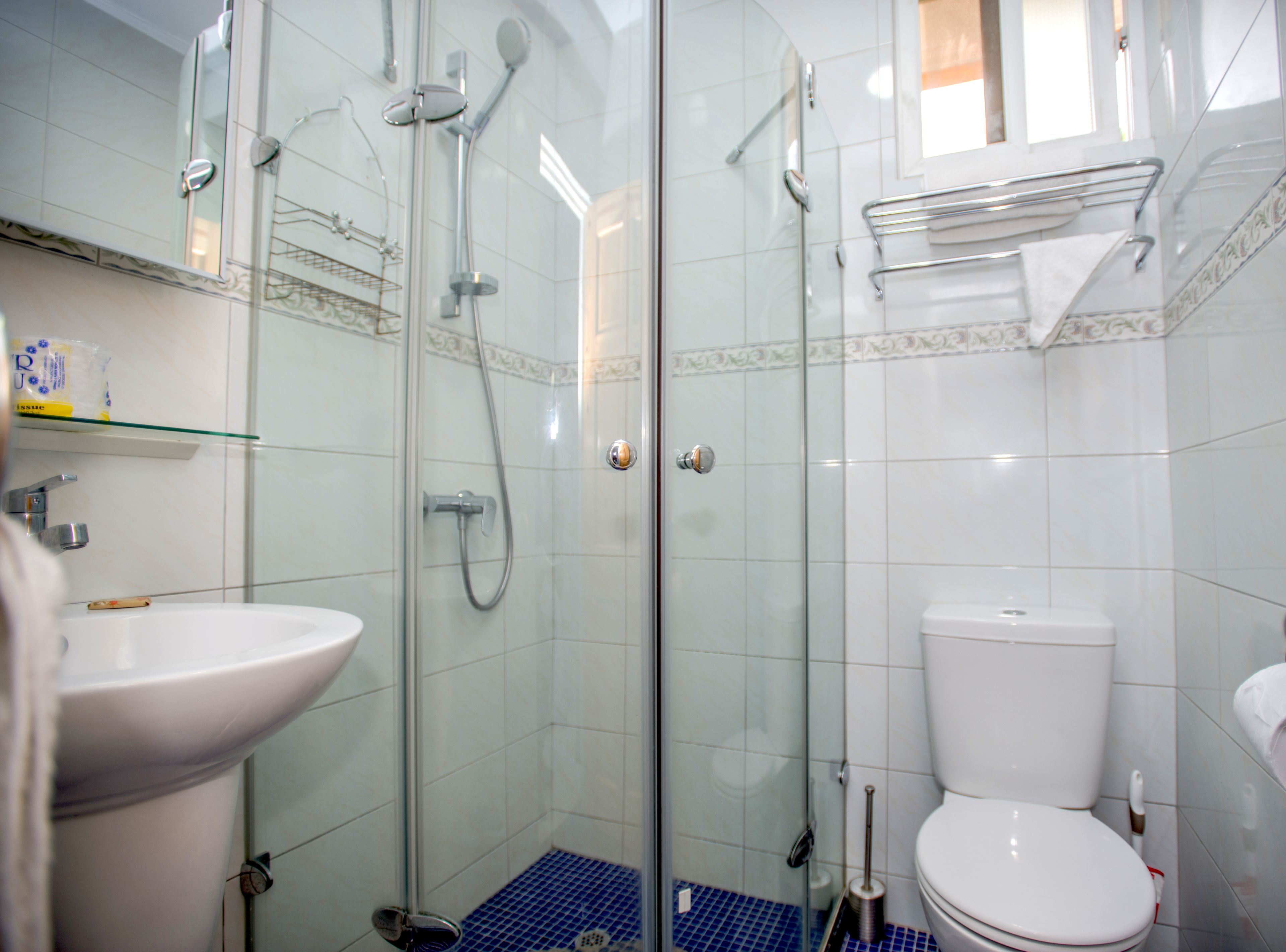 A modern bathroom with a glass-enclosed shower, a white toilet, and a sink.