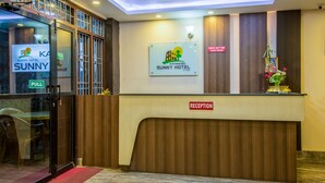 A reception area with a wooden counter, a sign for the Kathmandu Sunny Hotel, and a 'Check Out Time' sign. - Kathmandu Sunny Hotel (Kathmandu)