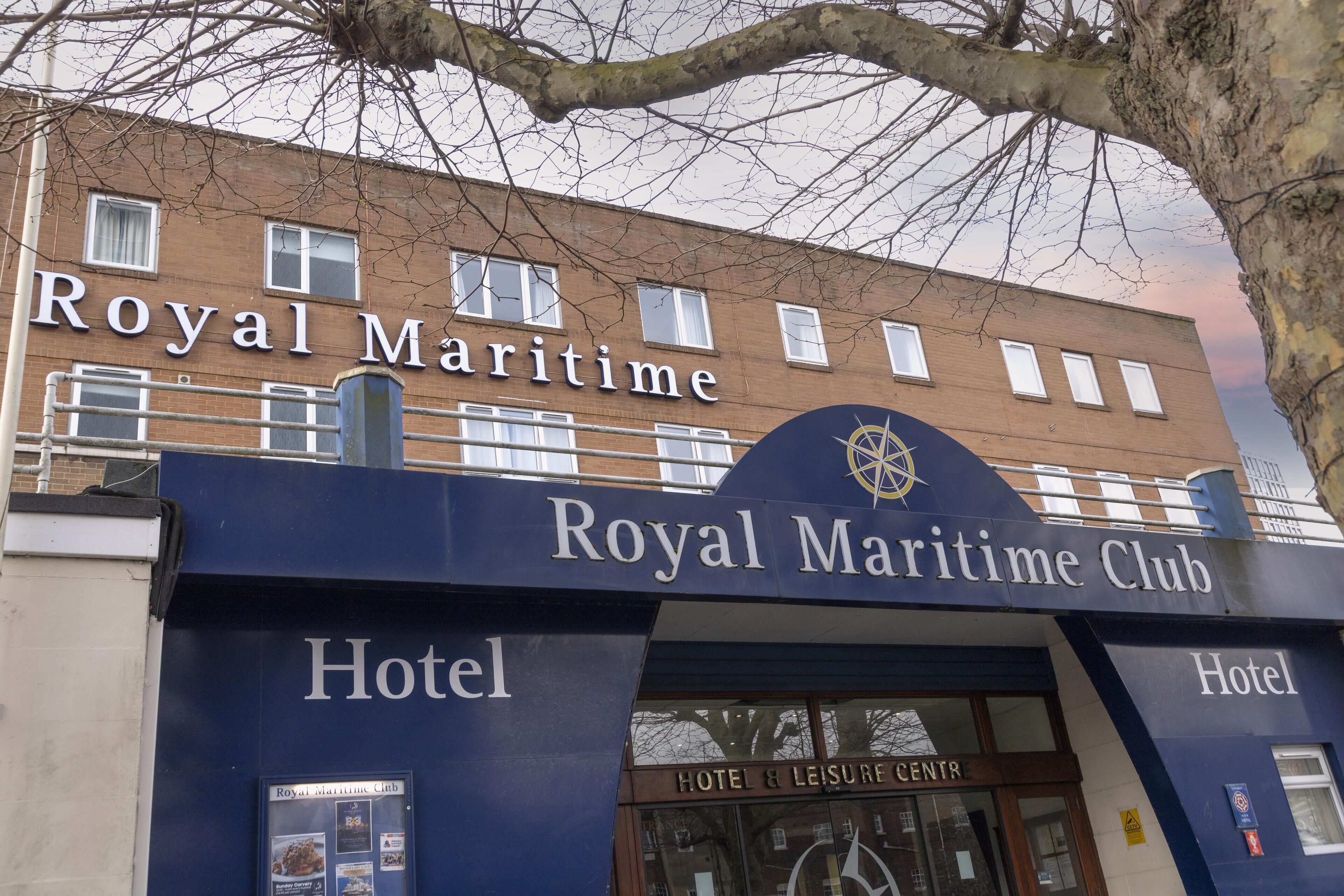 The exterior of the Royal Maritime Club Hotel with a prominent sign and entrance.