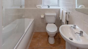 Un baño con bañera, inodoro y lavamanos.