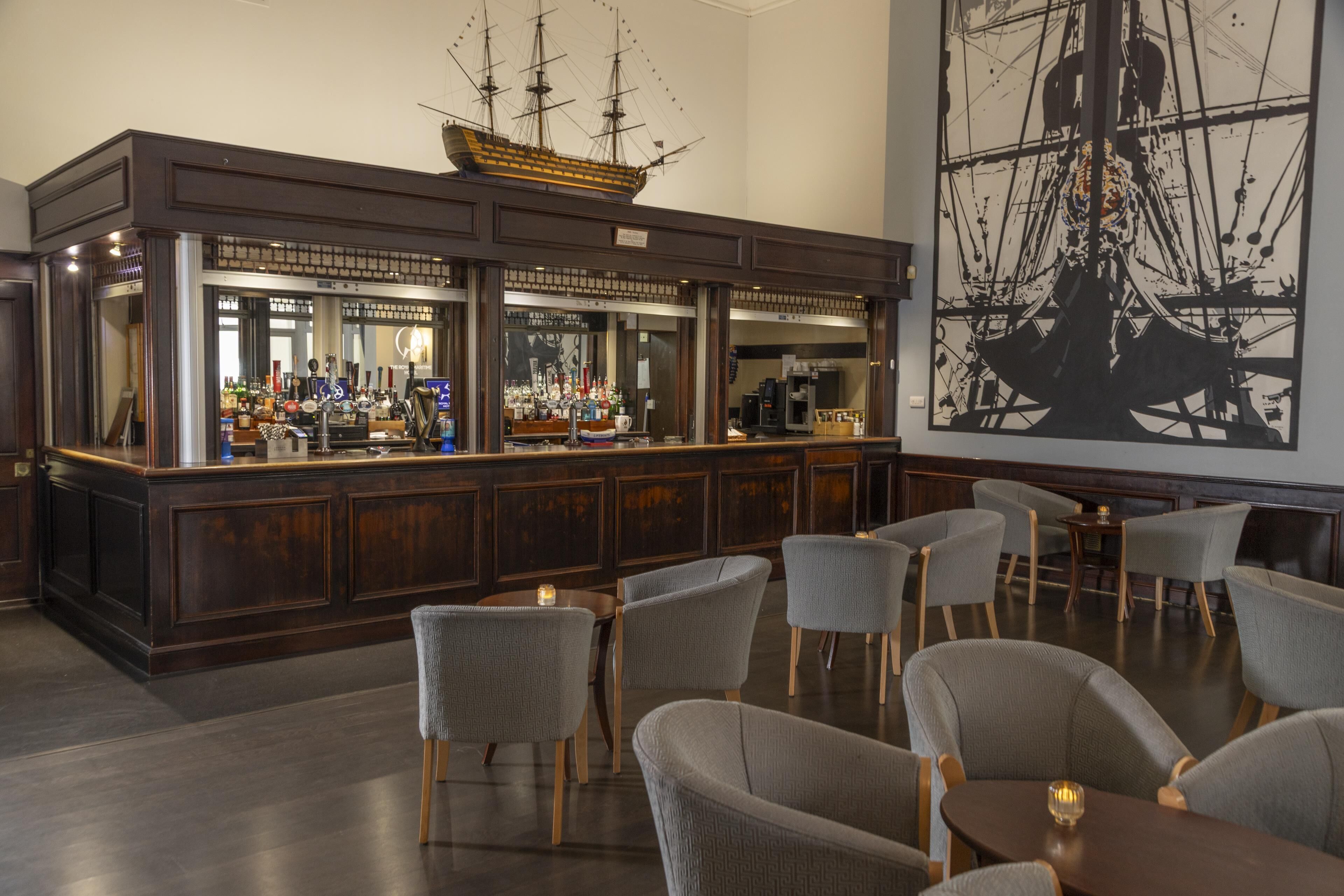 A bar area with a ship model, bar counters, and seating.