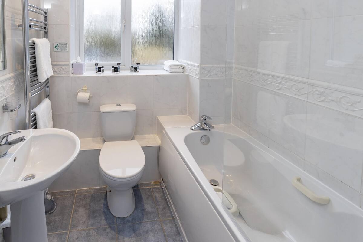 A bathroom with a toilet, sink, and bathtub.