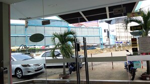 A view from inside a building looking out onto a street with parked cars and a motorcycle. - Hotel Jelai Temerloh (Temerloh)
