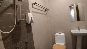 Kylpyhuone, jossa on suihku, wc, pesuallas ja pyyheteline.