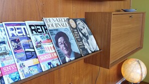 Un escritorio de madera con revistas, un globo terráqueo y una lámpara.