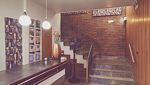 Una escalera con acabado de madera y un ventilador cerca de la base.