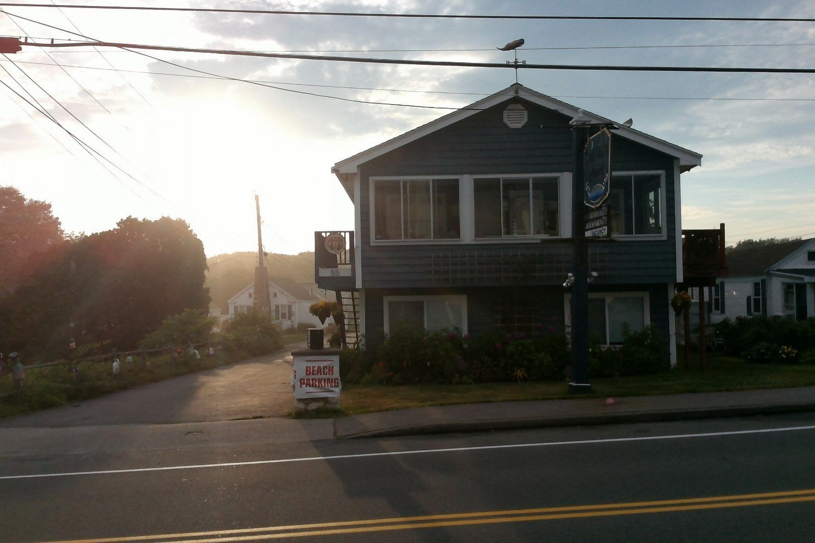 A two-story building with a sign indicating beach parking.