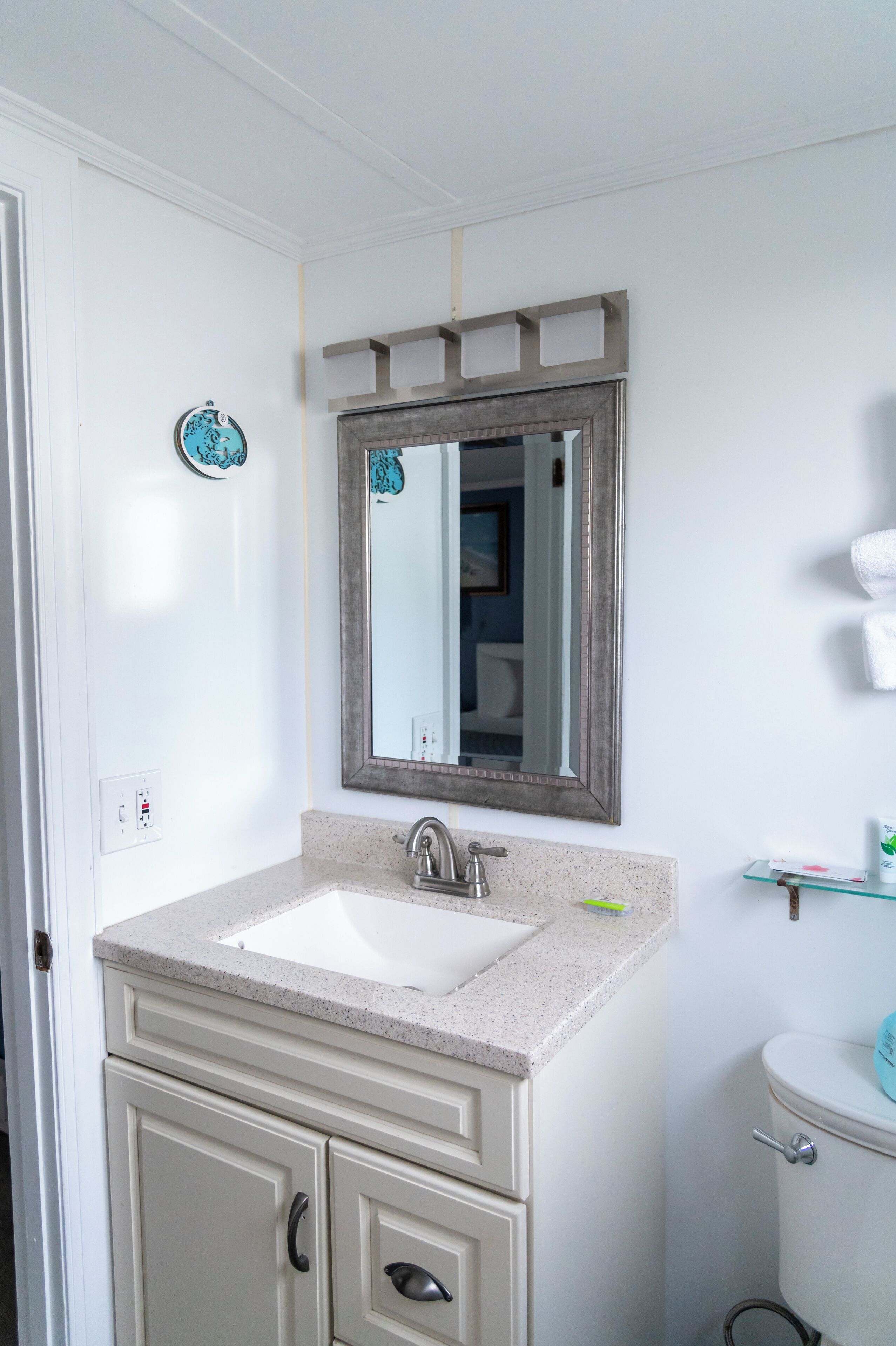 Ein Badezimmer mit Waschbecken, Spiegel und Toilette.