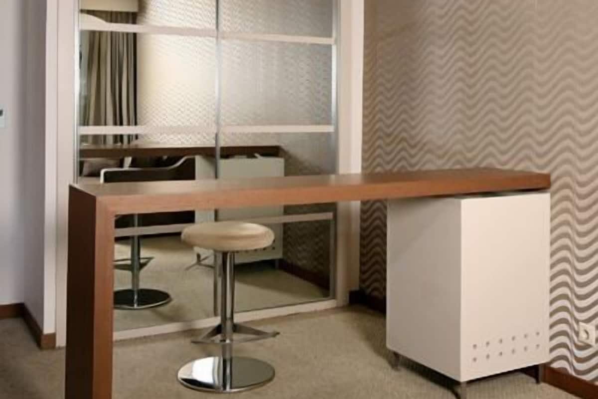 Eine moderne Küche mit einer Holzarbeitsplatte, zwei Barhocker und einem eingebauten Kühlschrank.