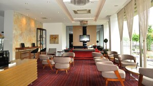 A hotel lobby with a reception desk, seating area, large chandelier, and a television. - Baliktasi City Hotel (Ordu)