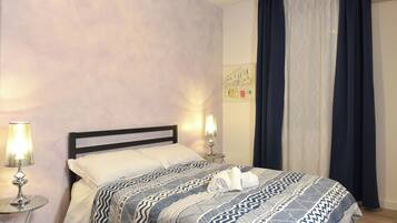 A neatly made bed with a patterned bedspread, two bedside lamps, and a wall art piece.