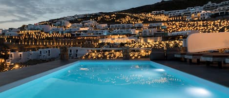 Una piscina al aire libre, sombrillas, tumbonas