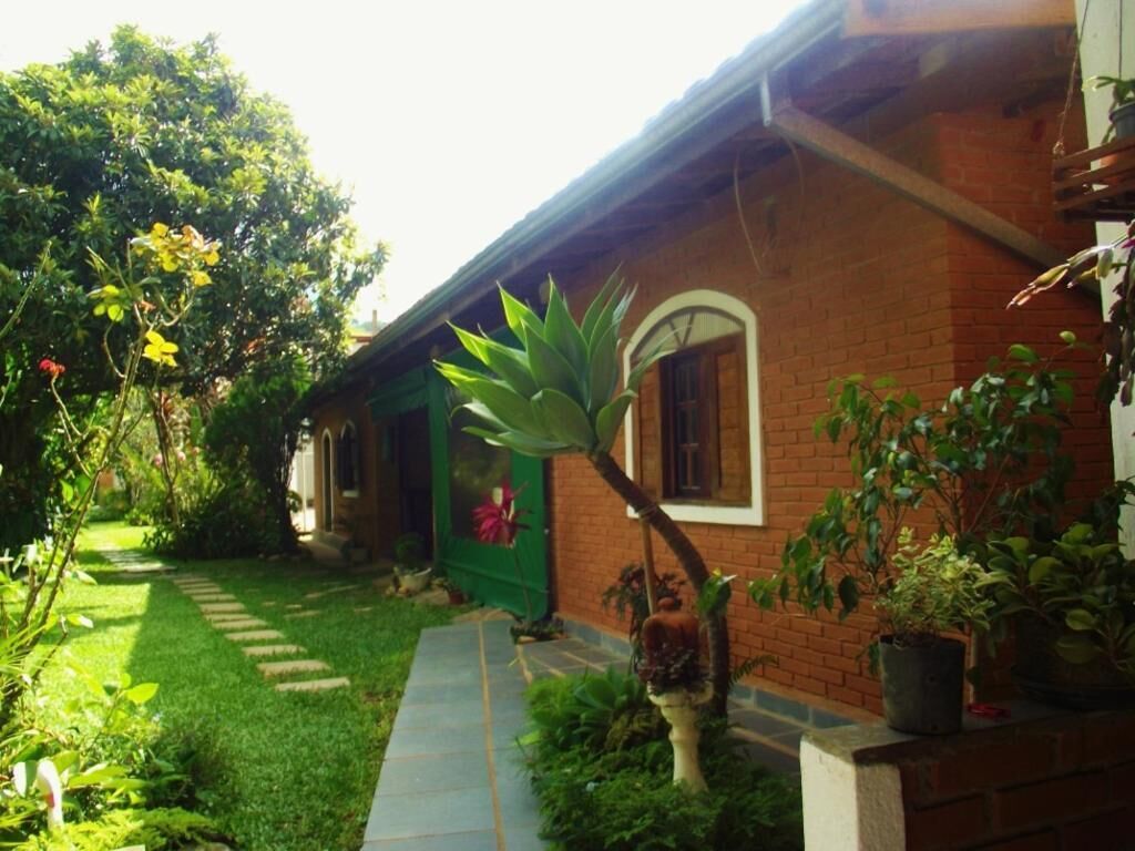 A brick house with a green door and a small garden with a pathway.