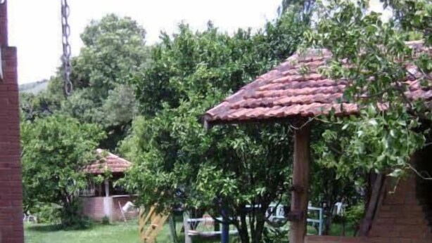 A garden pathway with stepping stones, brick structures, and greenery. - Pousada Nasa (São Bento do Sapucaí)