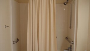 A bathroom with a bathtub, shower, and a towel rack. - Western Motel of Camilla (Camilla)