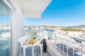 A balcony with a table set for breakfast, overlooking a coastal cityscape. - Hotel Playas del Rey (Calvia)