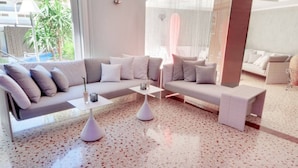 Un salon moderne avec un canapé d’angle, une table basse et un banc.