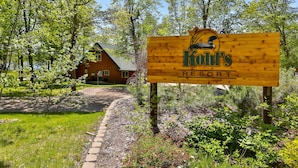 A wooden sign for Kofr's Resort with a rustic cabin in the background. - Kohl's Resort (Bemidji)