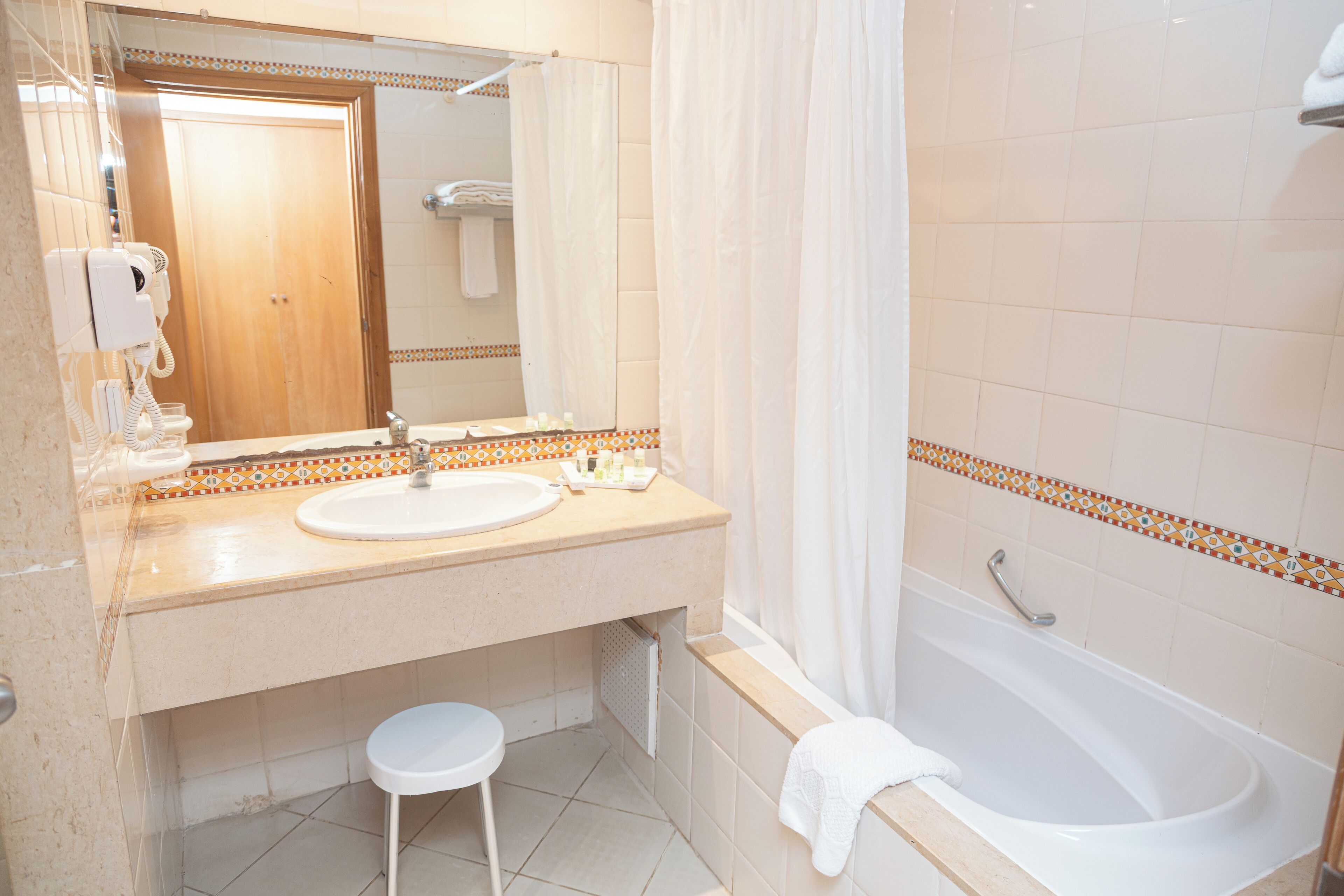 Une salle de bain avec un lavabo, un miroir et une baignoire.
