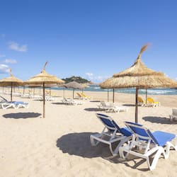 Praia particular, areia branca, espreguiçadeiras, guarda-sóis
