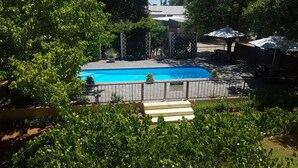 A swimming pool surrounded by a fenced area with a sign indicating swimming pool rules. - Celtis Country Lodge and Restaurant (Inxuba Yethemba)