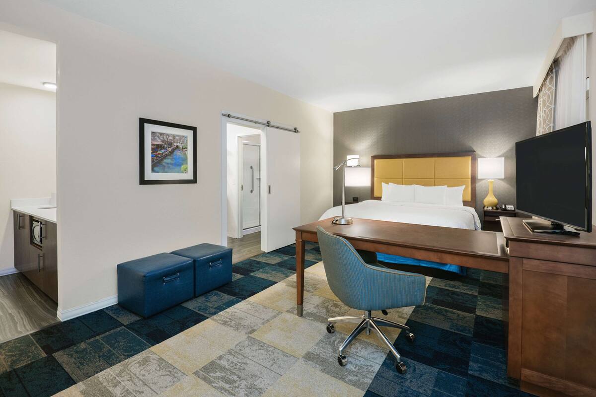 Une chambre d’hôtel équipée d’un lit, d’un bureau, d’une chaise et d’un téléviseur.