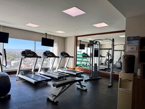 A gym with treadmills, a bench press, and a weight machine. - Hampton Inn by Hilton Durango (Durango)