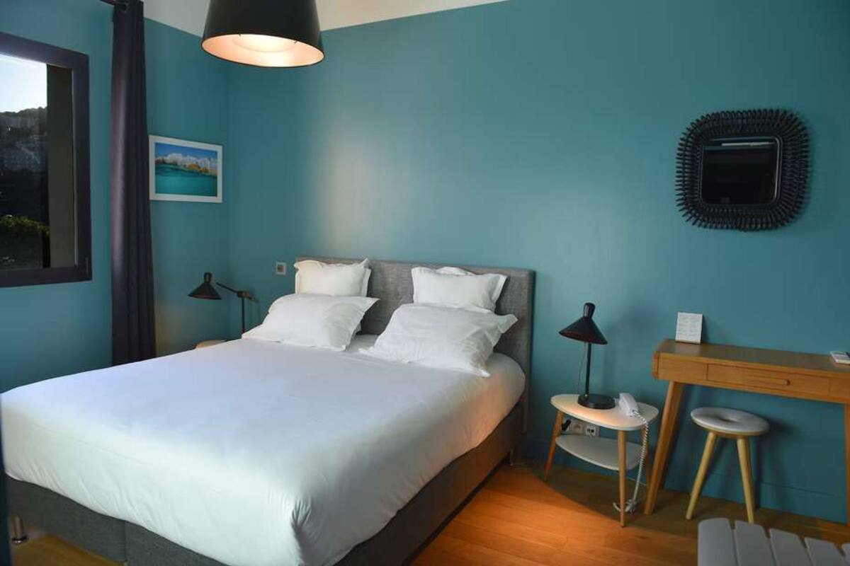 Une chambre à coucher comprenant un lit, des tables de chevet, un bureau et une chaise.