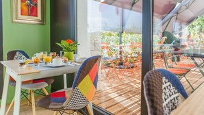 Un comedor con una mesa preparada para el desayuno, sillas y vistas al área de asientos exteriores.