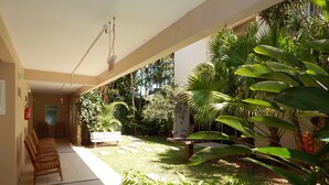 A covered outdoor area with a seating area, a fire extinguisher, and a sign indicating a bathroom. - Floripa Lodge Pousada & Bistrô (Florianópolis)