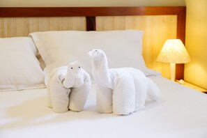 Restful retreat with a plush bed, wooden headboard, and soft table lamp.