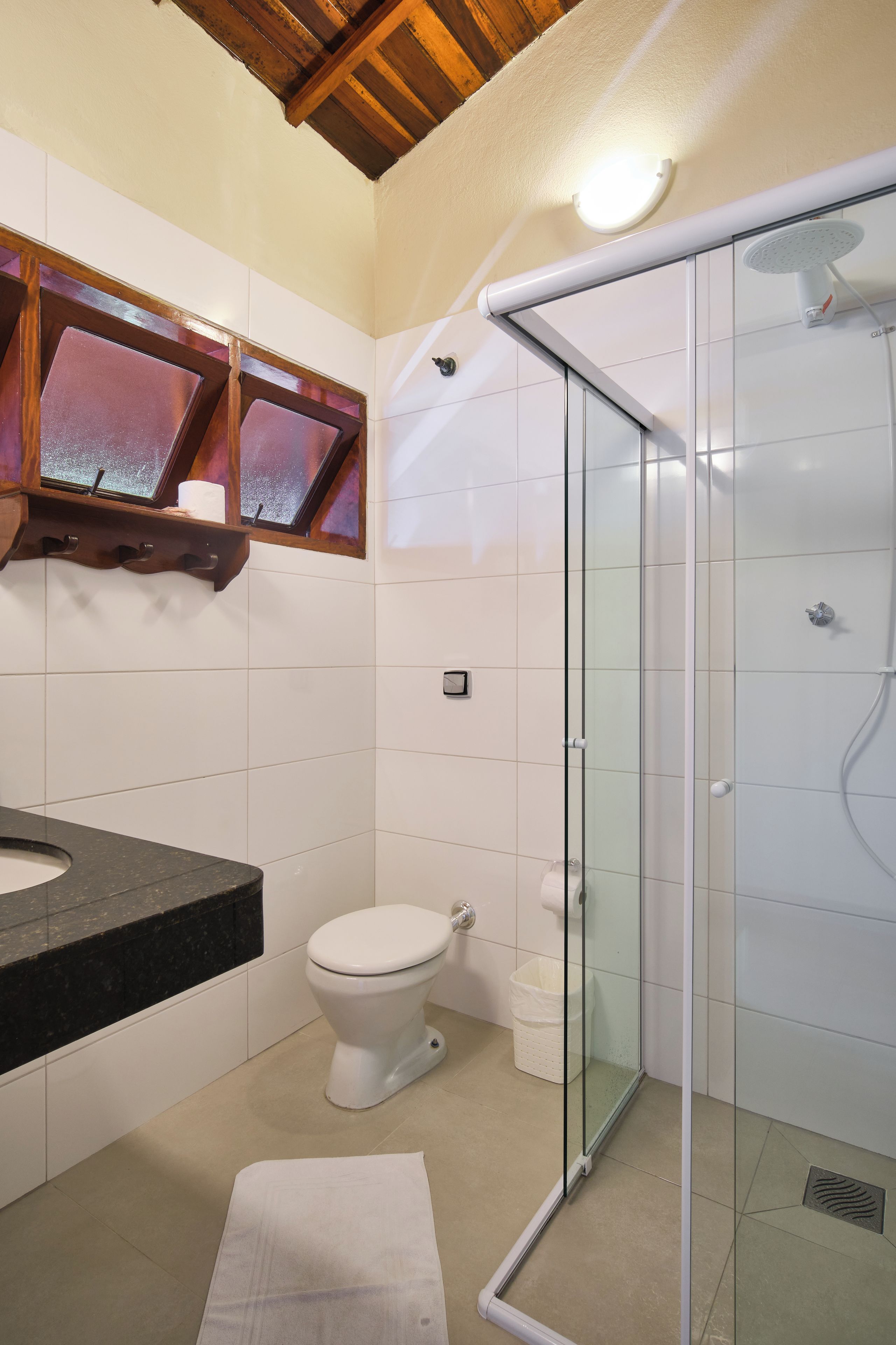 A bathroom with a glass shower enclosure, a toilet, and a vanity with a sink.