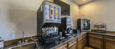 A modern kitchen with a built-in coffee machine, a microwave, and a refrigerator.