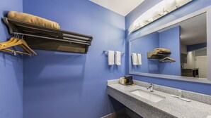 A bathroom with blue walls, a granite sink, a towel rack, and a mirror. - Home Place Inn Spring I-45 North & 1960 (Houston)