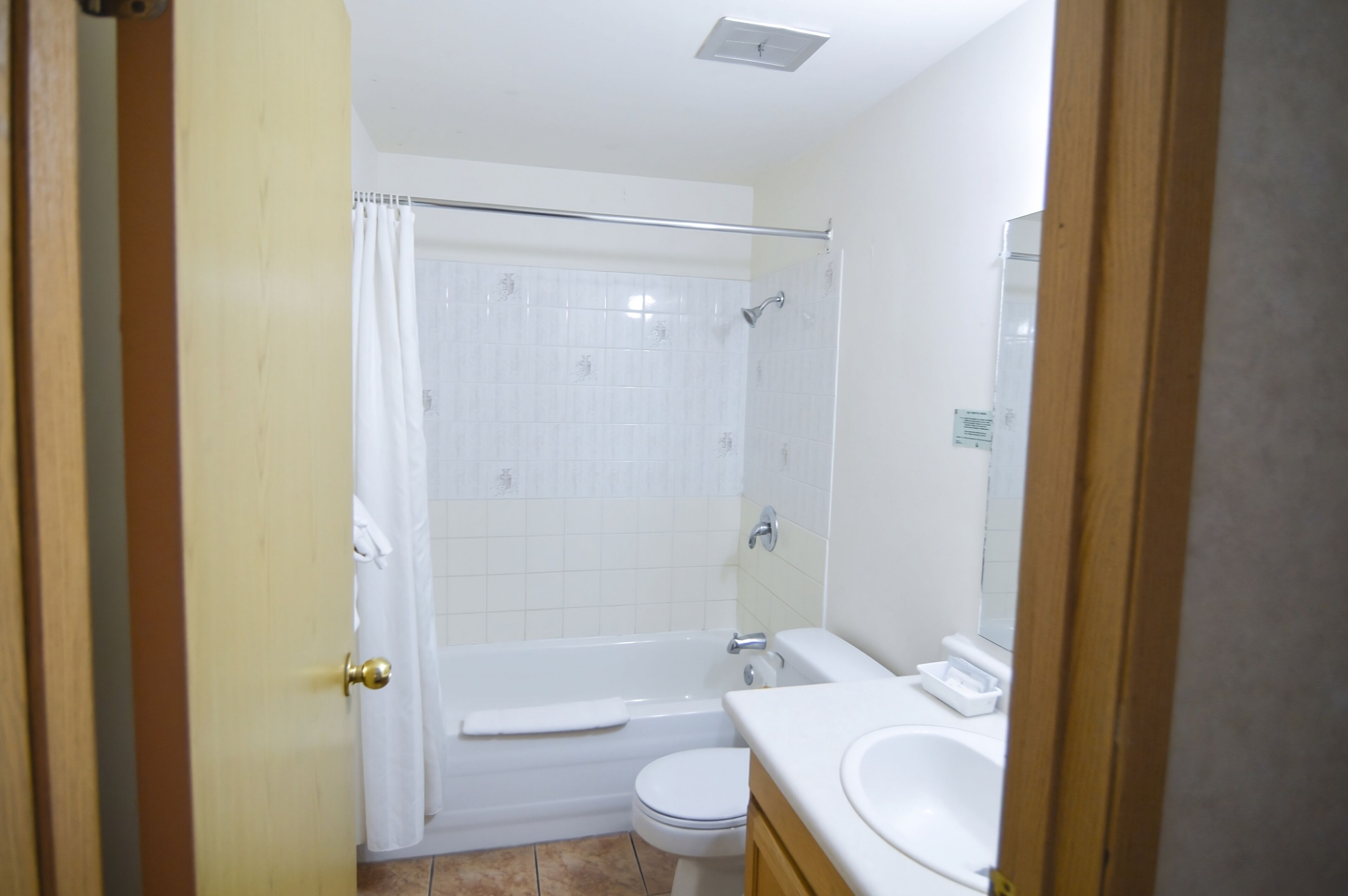 A bathroom with a shower, toilet, and sink.