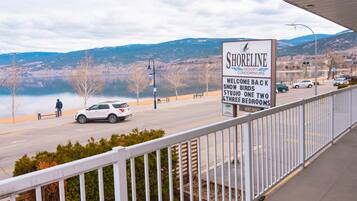 A signboard for Shoreline Resort Condominiums with a view of a lake and mountains in the background.