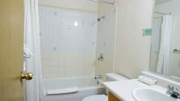 A bathroom with a bathtub, toilet, sink, and a mirror.