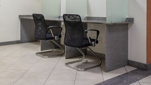 A hair salon with two chairs, a counter, and pendant lighting. - Hotel Vitória (Itajai)