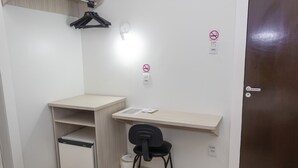 A small, clean room with a desk, chair, and a door. - Hotel Vitória (Itajai)