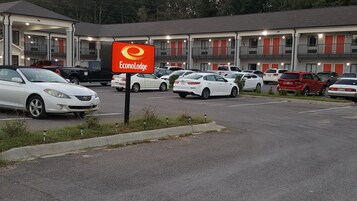 A parking lot with several cars, a sign for Econo Lodge, and a building with balconies and red doors.