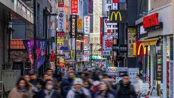 A busy urban street with various commercial signs and storefronts.