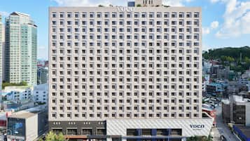 Un edificio de hotel de varios pisos, con una fachada de ventanas enrejada y techo plano.