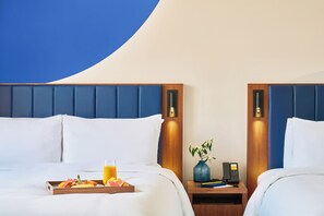 A hotel room with two beds, a tray of breakfast, a vase with flowers, and a bedside phone. - voco Seoul Myeongdong by IHG (Seoul)
