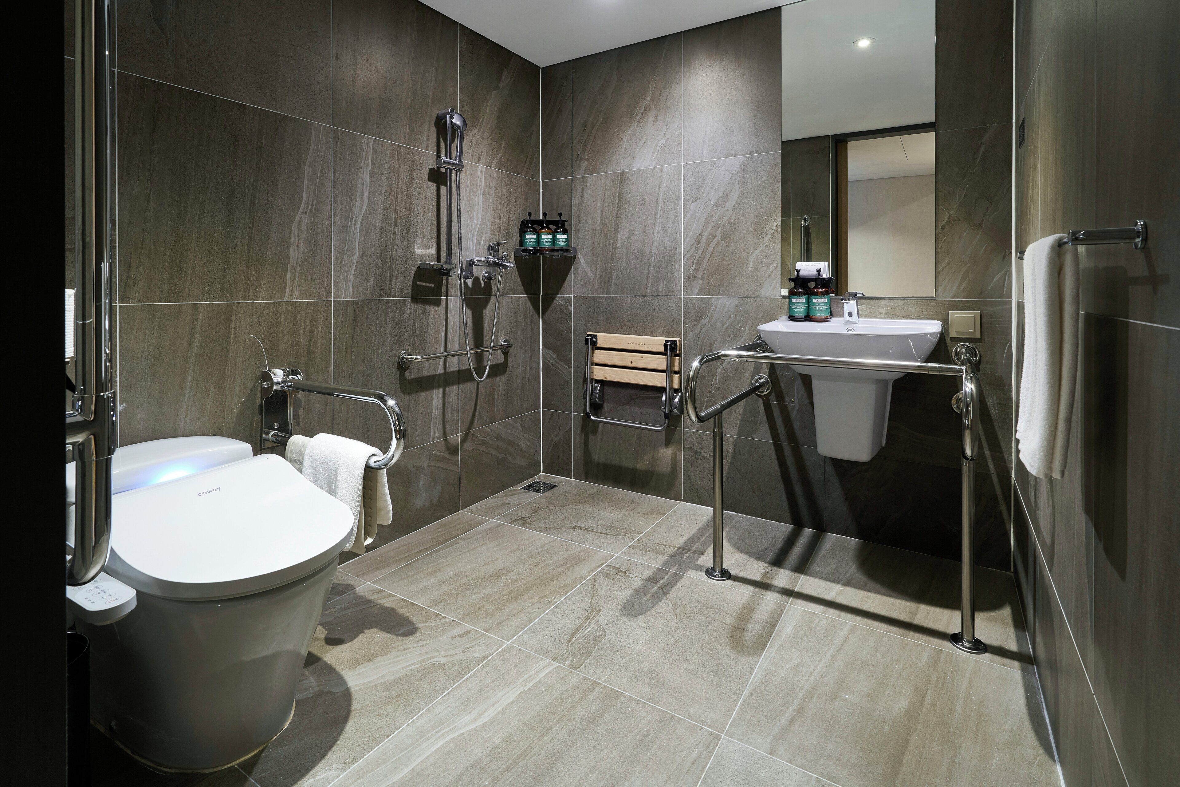 A modern bathroom with a toilet, bidet, and shower area.