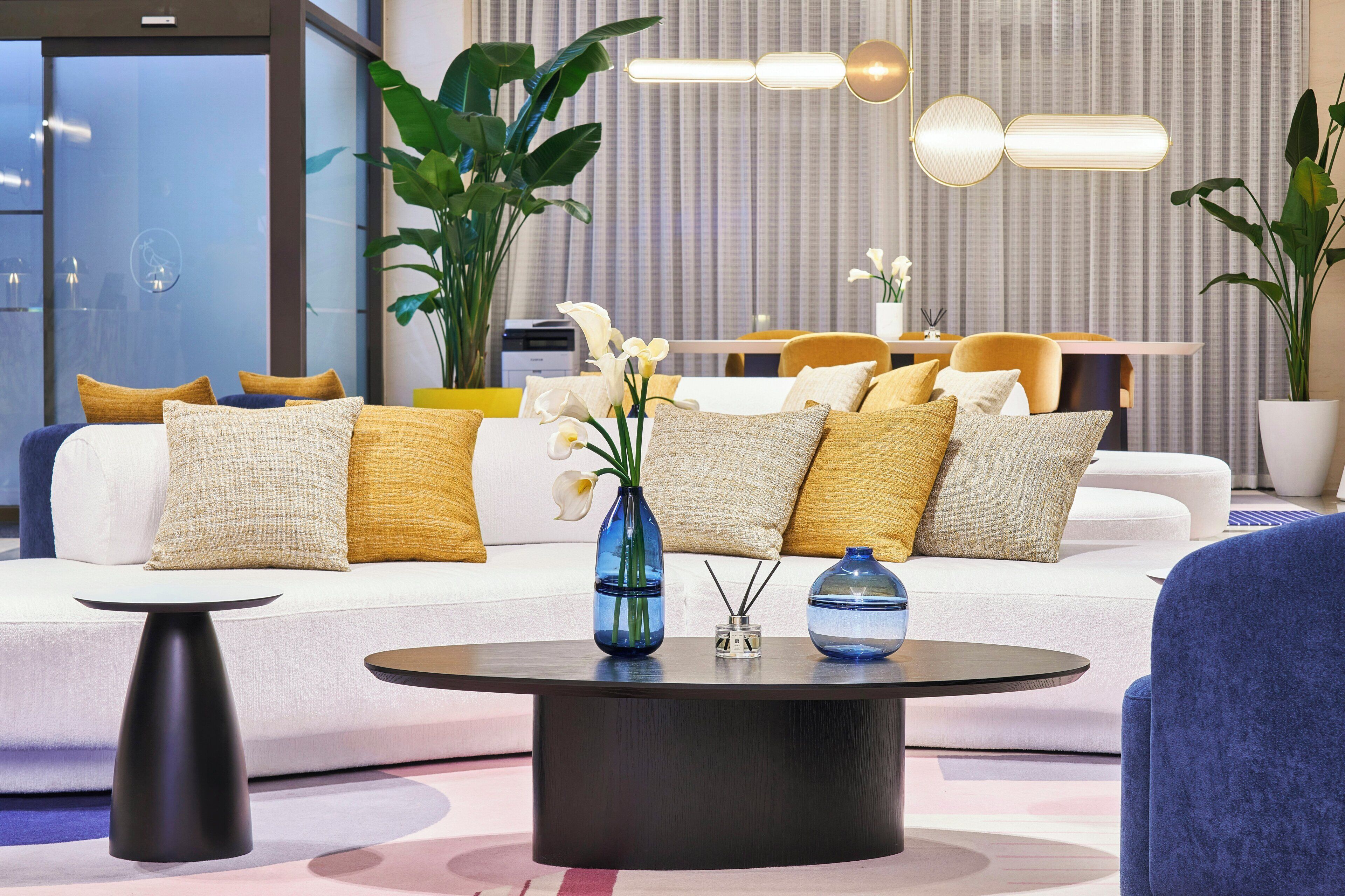 A modern living room with a sofa set, a coffee table, and decorative plants.