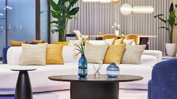 A modern living room with a sofa set, a coffee table, and decorative plants.