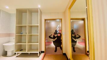 Een badkamer met een toilet, een wit schap en een spiegel.