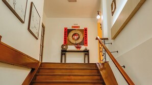 A wooden staircase leading to a room with a traditional Chinese altar, framed artwork on the walls, and a wooden handrail. - Fomecs Boutique Hotel, Jonker Street (Malacca City)